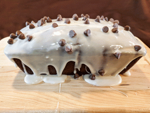 chocolate chips and frosting on chocolate bread on cutting board