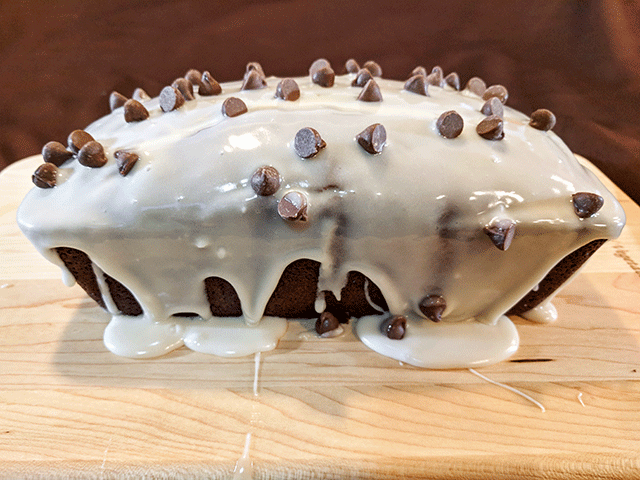 chocolate chips and frosting on chocolate bread on cutting board