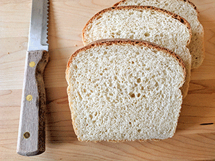 Cottage bread on cutting board next to bread knife