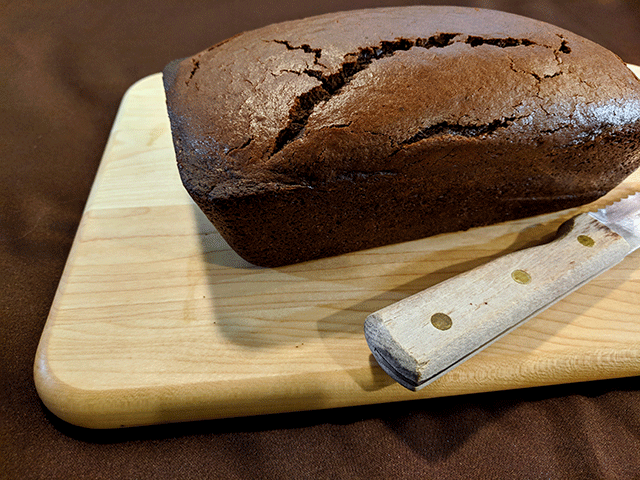 finished chocolate bread on cutting board next to bread knife