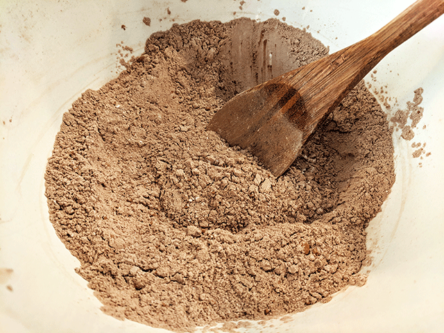 cocoa and flour in bowl with mixing spoon to make Chocolate Bread With Marshmallow Glaze