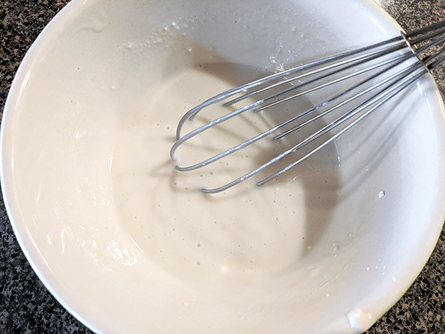 marshmallow glaze in a bowl with a whisk
