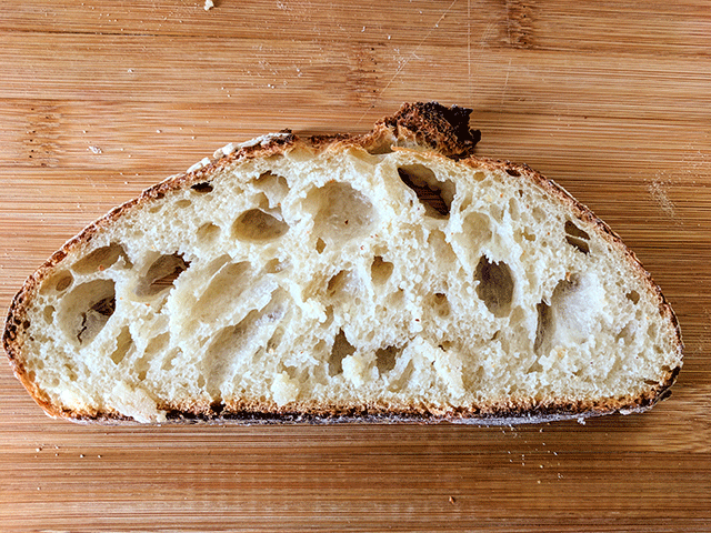 Slice of No Knead Artisan-Style Sourdough Bread on Cutting Board