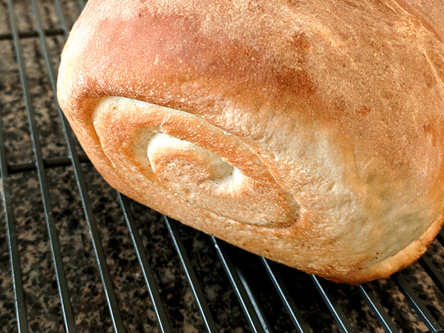 Baked cinnamon swirl bread cooling on a rack
