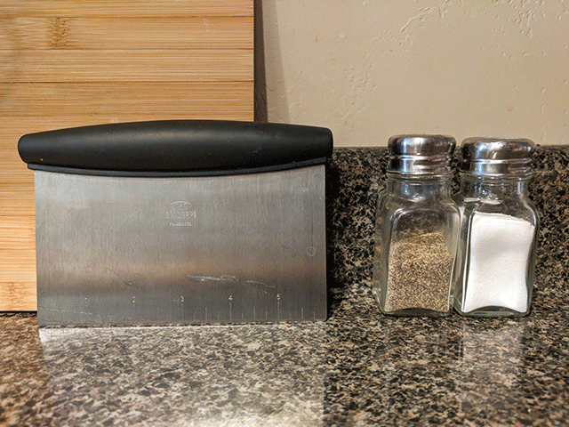 dough chopper on countertop next to salt and pepper. Items for beginner bakers. 