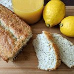 Lemon poppyseed bread next to lemons and juice