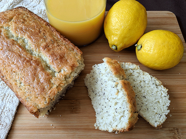 Lemon poppyseed bread next to lemons and juice