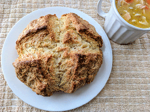 Irish Soda Bread on Plate Next to Bowl of Soup