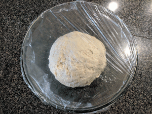 covered dough ball in bowl