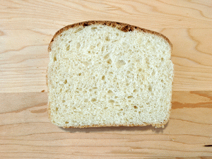 single slice of crusty sourdough cottage bread on cutting board