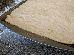 Focaccia dough stretched to fit pan