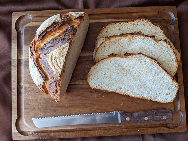 sliced sourdough discard bread on cutting board with bread knife