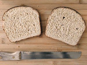 two slices of honey whole wheat sourdough next to bread knife