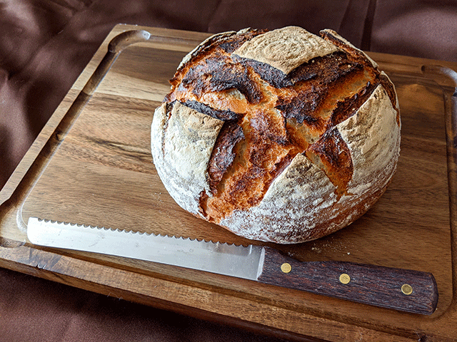 finished sourdough discard bread on cutting board with cutting knife