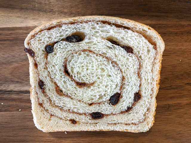 slice of cinnamon swirl raisin sourdough discard bread on cutting board