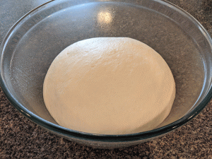 cinnamon raisin sourdough bread dough ball rising in glass bowl