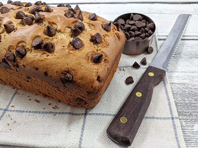 Peanut Butter Chocolate Chip Bread with Knife on tea towel on wooden table