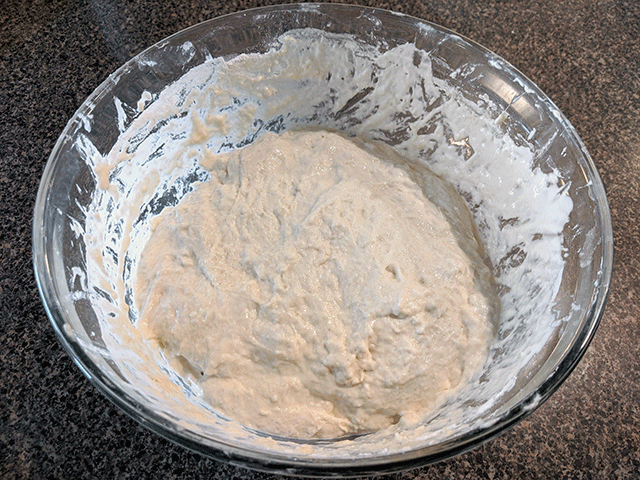 flour mixed with sourdough starter in a glass bowl