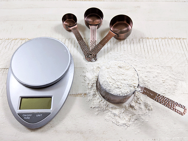 measuring cups with flour next to kitchen scale for 5 Beginning Bread Baking Mistakes and How to Avoid Them