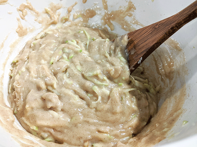 Batter for zucchini walnut bread mixed with wooden spoon