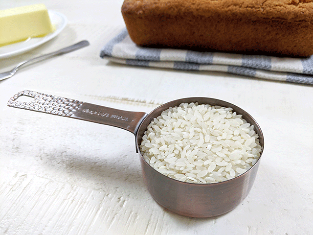 rice in measuring cup with bread and butter