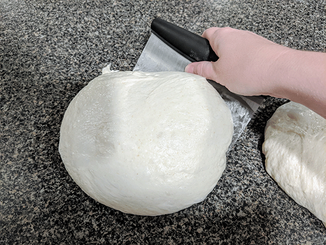 hand shaping dough round with pastry cutter