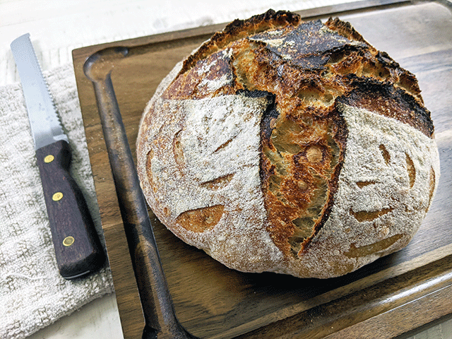 white n wheat sourdough on cutting board next to bread knife