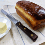 english muffin bread knext to bread knife and butter on a plate