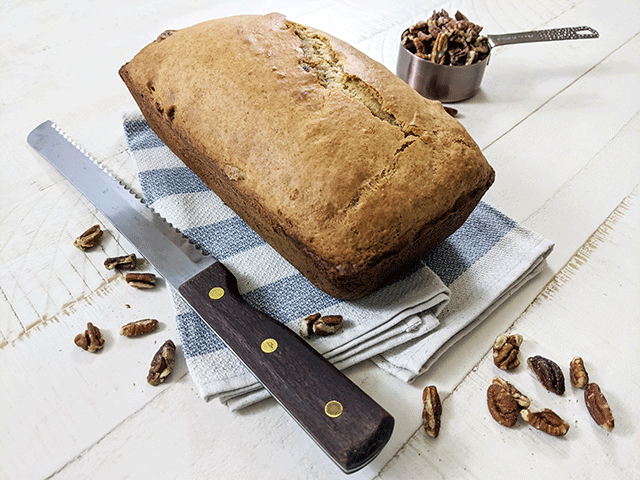 uncut butter pecan bread on tea towel next to bread knife