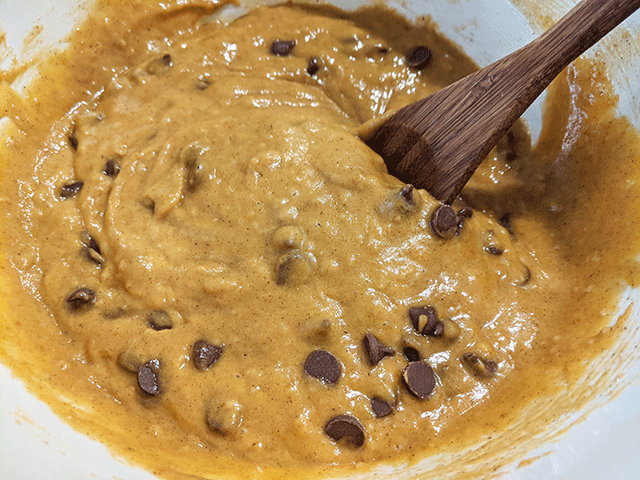 pumpkin bread batter with chocolate chips and wooden spoon