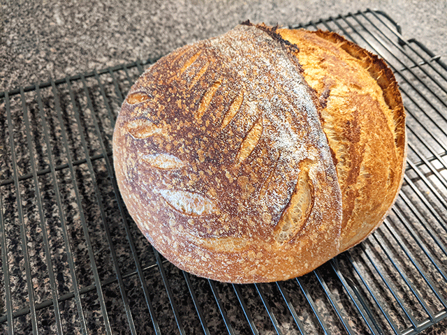 white and wheat and rye artisan bread on cooling rack