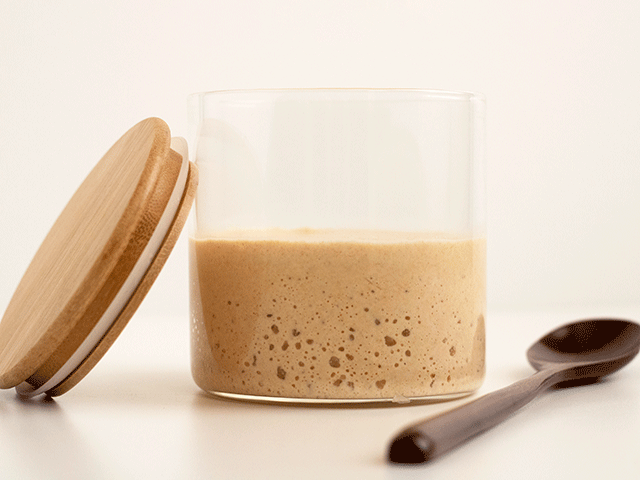 does the float test work? a container of sourdough starter next to a spoon