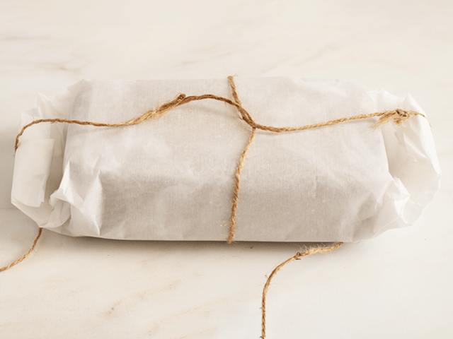 A loaf wrapped in parchment and twine for How to Wrap Quick Bread for Gifting