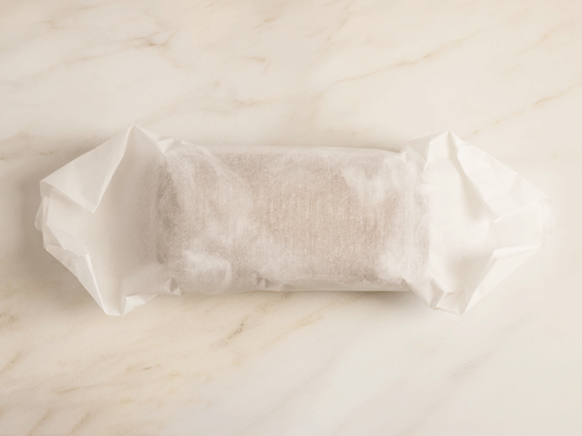 A loaf wrapped in parchment for How to Wrap Quick Bread for Gifting
