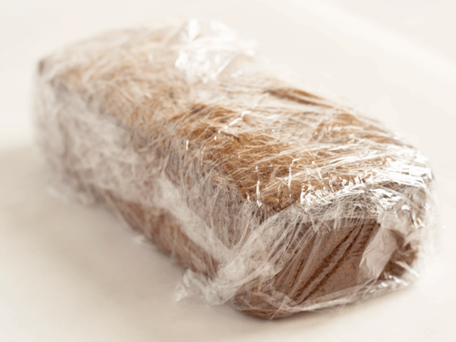 A loaf wrapped in plastic wrap for How to Wrap Quick Bread for Gifting