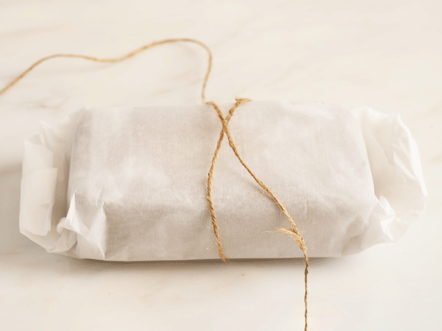A loaf wrapped in parchment and twine for How to Wrap Quick Bread for Gifting